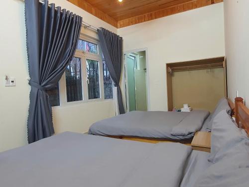 a bedroom with two beds and a window at Mây Villa Garden Đà Lạt in Xuan An