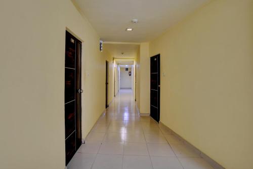an empty hallway with two doors and a tile floor at Hotel O Konark Inn in Naroda