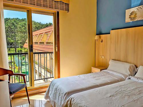 a bedroom with a bed and a large window at Hotel Mar del Norte 3000 in O Grove
