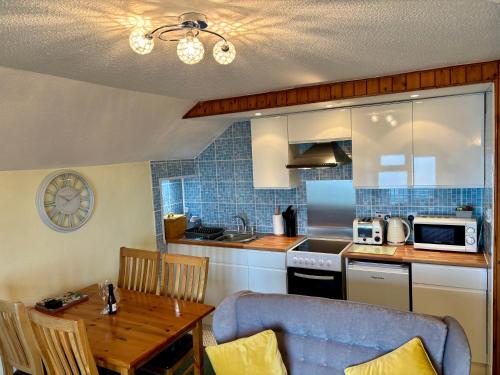 a kitchen with a table and a blue tiled wall at The Lookout in Ilfracombe