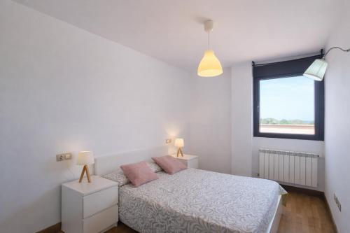 a white bedroom with a bed and a window at El Ático de Celorio – Piscina, Terraza y Playa in Celorio