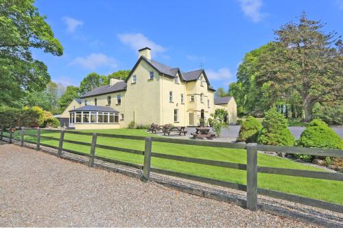 a large house with a fence in front of it at Carrygerry Country House in Shannon