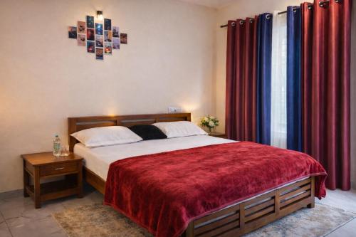 a bedroom with a large bed with red curtains at LASplore munnar in Kallar Vattiyar