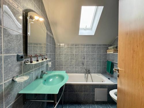 a bathroom with a sink and a bath tub at Penzion U Kapličky in Malá Hraštice