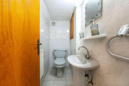 a bathroom with a white toilet and a sink at Villa Adonis Large Private Pool Walk to Beach in Argaka