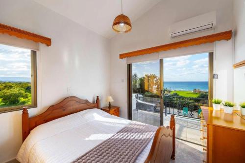 a bedroom with a bed and a view of the ocean at Villa Adonis Large Private Pool Walk to Beach in Argaka