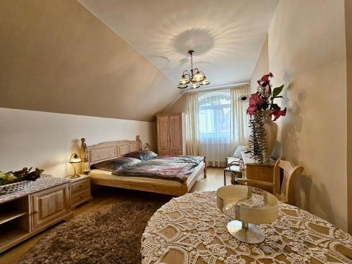 a bedroom with a bed and a table at Penzion U Kapličky in Malá Hraštice