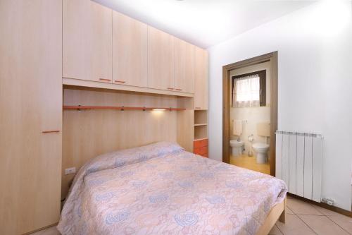 a small bedroom with a bed and a toilet at Villaggio dei Fiori in Caorle