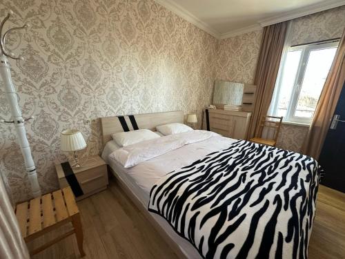 a zebra print bedroom with a bed and a window at Amiran's Lake in Tbilisi City