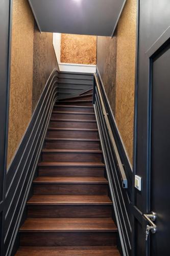 a flight of stairs in a building with a door at ATELIER DE BERCK - Gîte 6p avec Parking GRATUIT & TERRASSE in Berck-sur-Mer
