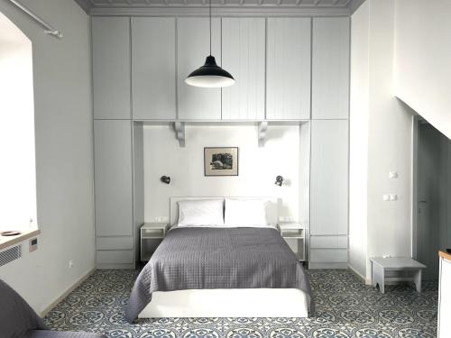 a bedroom with a bed and a pendant light at Mercato Vecchio Guesthouse in Hydra