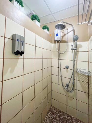 a shower in a bathroom with white tiles at Little Treasure Tagaytay-Flora in Tagaytay