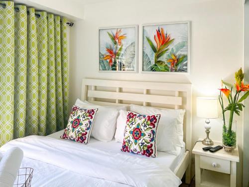 a bedroom with a white bed with two pillows at Little Treasure Tagaytay-Flora in Tagaytay