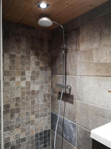 a shower with a glass door in a bathroom at CHALET COSY A LA MONTAGNE AVEC SAUNA TONNEAU situé à St Laurent en Grandvaux - Proche lacs cascades et pistes de ski in Saint-Laurent-en-Grandvaux