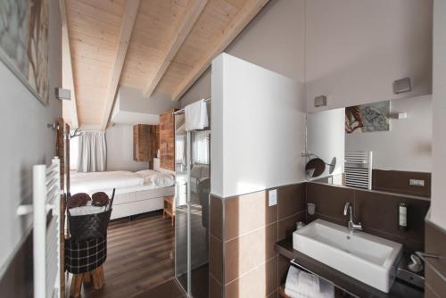 a bathroom with a sink and a bed in a room at Chalet Vites Mountain Hotel in Canazei