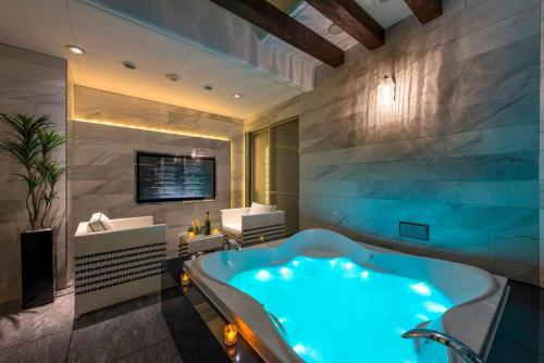a bathroom with a large blue tub in a room at ホテルルアン横浜 in Kikuna