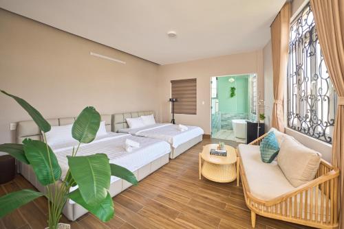 a bedroom with a bed and a couch and a table at Minh Nhat Villa - 3S Villa in Cồn Giả Viên