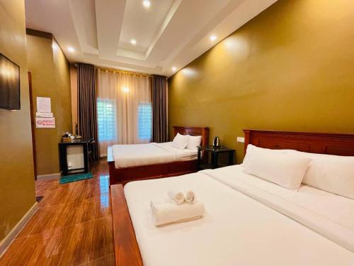 a hotel room with two beds with towels on them at Green Island Bungalows in Kampot