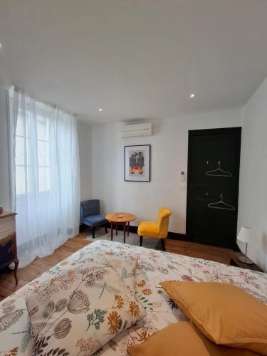 a bedroom with a large bed and a table at La maison de Lau in Salies-de-Béarn