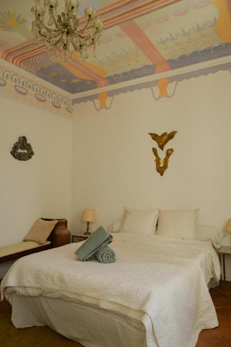 a bedroom with a white bed with a colorful ceiling at Maison d'artistes - Pavillon Southway in Marseille