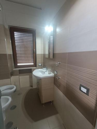 a bathroom with a sink and a toilet and a window at Suite Del Redentore 44 in Caserta