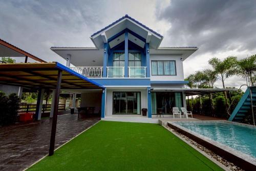 a house with a swimming pool next to a house at BanIngKhao Pool Villa Sriracha in Ban Hup Bon