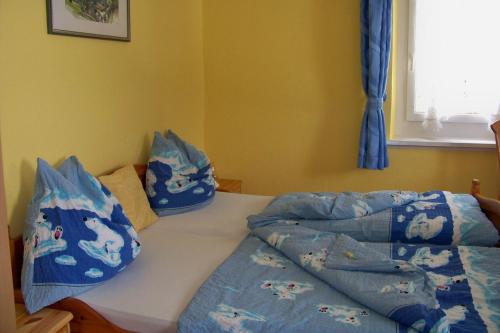 a bedroom with a bed with blue sheets and pillows at Gästehaus Alpina in Berchtesgaden