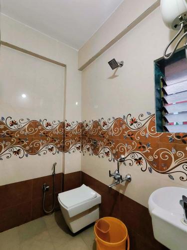 a bathroom with a toilet and a sink at Samudrasneha Resort in Nagaon