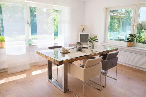 a dining room with a glass table and chairs at Ferienwohnung Westerwaldblick großzügige Wohlfühloase mit Terrasse in Oberelbert
