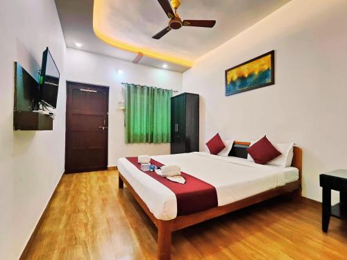 a bedroom with a bed with a ceiling fan at Samudrasneha Resort in Nagaon