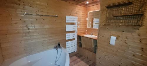 Monthureux-sur-SaôneにあるGite Coeurdacierの浴槽と洗面台を備えた木製のバスルーム