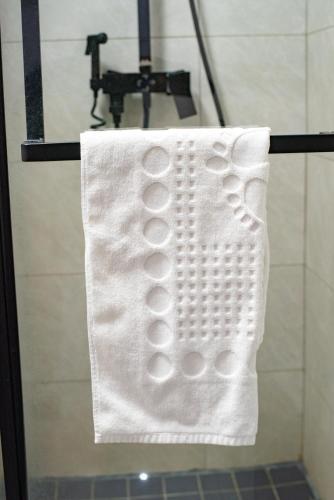 a white towel is hanging in a shower stall at 7th Heaven Apartments in Gaborone