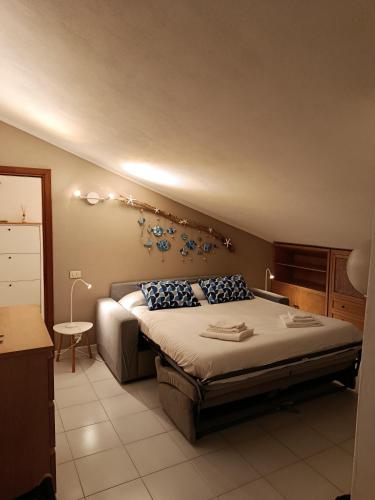 a bedroom with a large bed with blue pillows at Casa nel parco 3 camere 2 bagni 6 ospiti in Luni