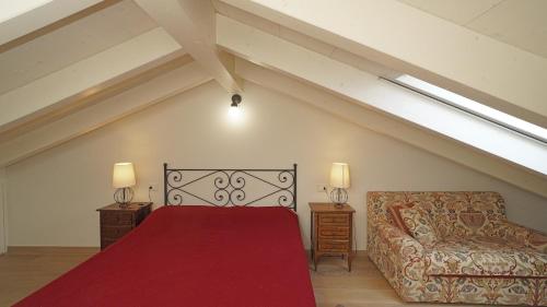 a bedroom with a red bed and a couch at Garda Prestige Retreat in Moniga