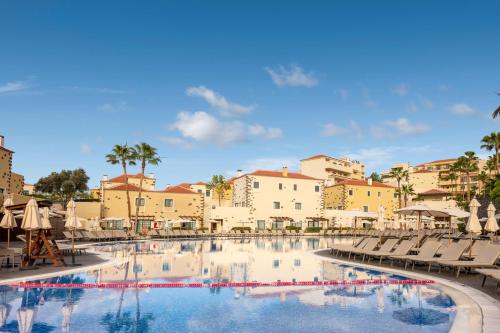 a swimming pool with chairs and umbrellas in a resort at GF Isabel in Adeje