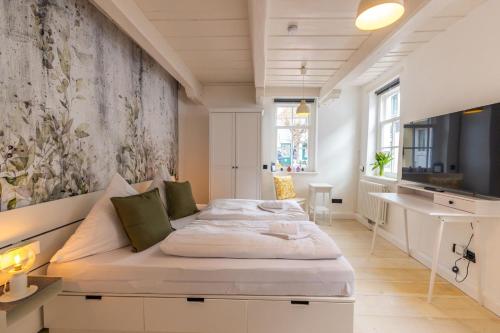 a bedroom with a bed and a tv on a wall at K94 Fischerhaus in Greetsiel