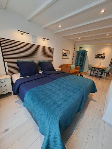 a bedroom with a large bed with a blue blanket at Dulce Tierra - vakantiewoning in Zoutelande