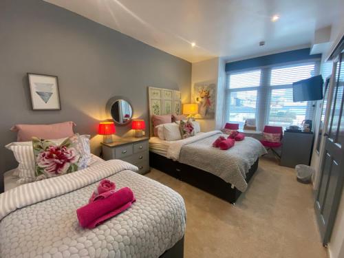 a bedroom with two beds with pink towels on them at The Mayfield Hotel in Blackpool
