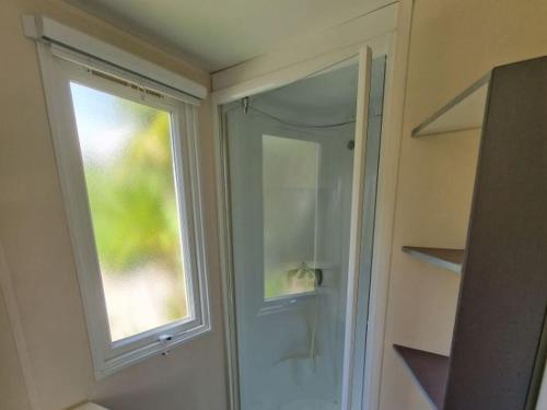 a bathroom with a glass door and a window at Camping La Provençale - Maeva in Mandelieu-La Napoule