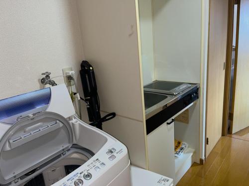 a washing machine in a room with a mirror at ホテル駅前汐舎 in Nagasaki