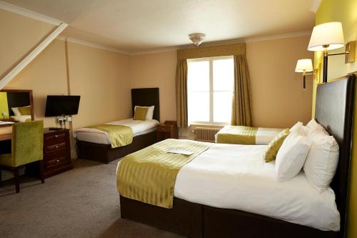 a hotel room with two beds and a desk at Red Lion Hotel by Greene King Inns in Fareham