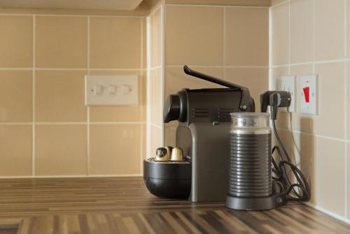 a coffee machine sitting on a counter with a cup at Steps from Train Station - Modern 2-Bedroom with Balcony & Cambridge Amenities, Family Friendly in Cambridge