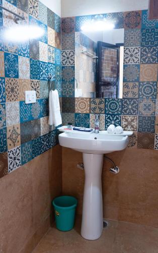 a bathroom with a sink and a mirror at Pinnacle view in Manāli