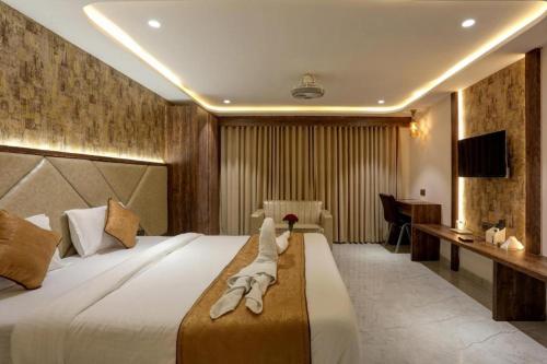 a hotel room with a large bed and a desk at Ramya Residency Navi Mumbai in Navi Mumbai