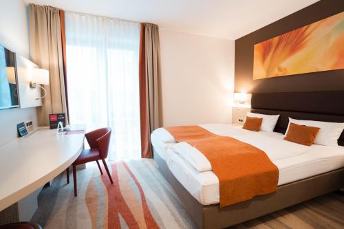 a hotel room with a large bed and a desk and a desk at Hotel Kapuzinerhof in Biberach an der Riß