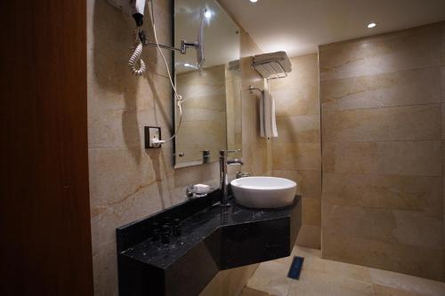 a bathroom with a sink and a shower at Coral Hotel Karbala in Karbala