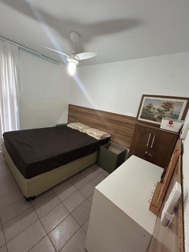 a small bedroom with a bed and a ceiling fan at Chalé Gratidão - Camping Carrion - ITU in Itu