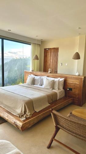 a bedroom with a large bed with a large window at Mountainparkbali in Baturaja