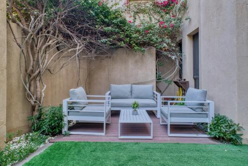 two chairs and a coffee table on a patio at GuestReady - 1BR | Private Garden - Burj Khalifa in Dubai