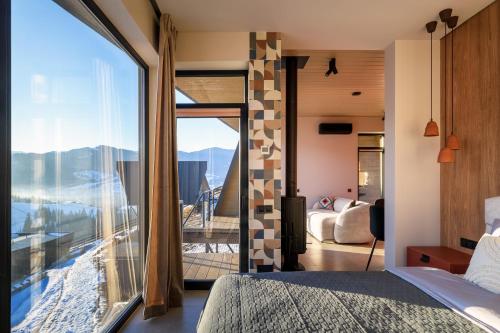 a bedroom with a view of the mountains through a window at Emshir Villas in Krasnik